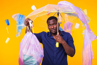 问题垃圾塑料回收<strong>污染环境</strong>概念困惑男人。携带垃圾袋黄色的背景