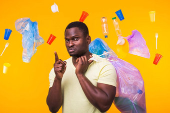 问题垃圾塑料回收<strong>污染环境</strong>概念非洲美国男人。携带垃圾回收指出黄色的背景