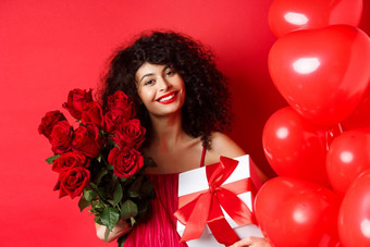 浪漫的女人收到花束花礼物假期站<strong>心气球</strong>红色的背景微笑感激的