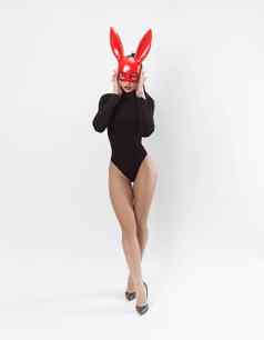 女人红色的兔子面具黑色的紧身衣裤白色背景