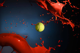 孤立的拍摄红色的油漆飞溅网球球蓝色的背景