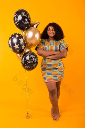 假期聚会，<strong>派</strong>对有趣的概念肖像<strong>微</strong>笑年轻的非裔美国人年轻的女人甜蜜的黄色的背景持有气球