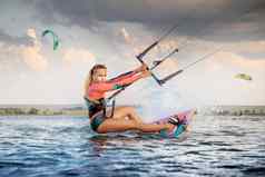 前面视图专业风筝冲浪者女人游乐设施董事会板材手莱曼湖海水晚上水溅太阳眩光水体育