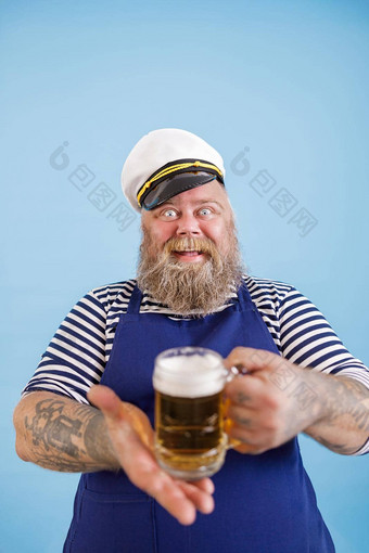 快乐的丰满男人。<strong>水手服</strong>装提供了玻璃杯子啤酒光蓝色的背景