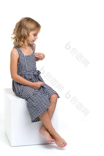 肖像美丽的女孩坐着白色多维数据集