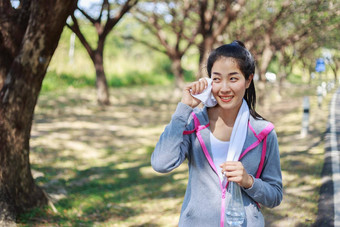 运动女人休息擦拭汗水毛巾锻炼体育运动练习在户外公园