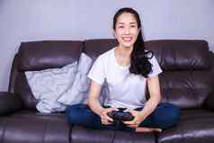 女人操纵杆控制器玩视频游戏沙发生活房间