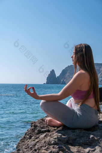 年轻的女人长头发健身教练运动服装紧身裤上衣伸展运动普拉提瑜伽席海阳光明媚的一天女健身瑜伽例程概念