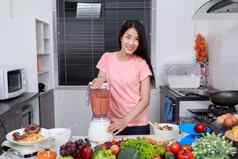 女人使蔬菜冰沙搅拌机厨房