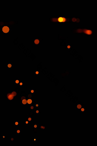 橙色散景黑色的背景燃烧模糊火花火粒子燃烧余烬飞发光孤立的晚上天空
