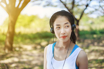 年轻的运动女人听音乐耳机<strong>公园</strong>