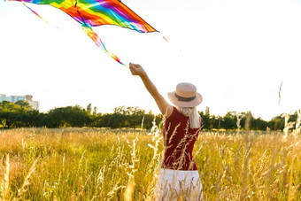 美女孩运行风筝场美丽的年轻的女人飞行色彩斑斓的风筝清晰的蓝色的天空免费的自由概念情绪健康的生活方式