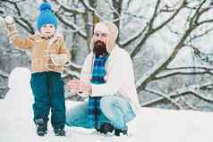 冬天父亲儿子玩户外快乐爸爸孩子玩冬天圣诞节时间快乐孩子玩雪球白色冬天背景快乐爱的家庭