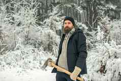 男人。伐木工人斧户外冬天有胡子的男人。斧雪森林