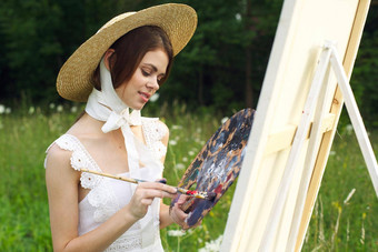 女人白色衣服在户外艺术家画画架