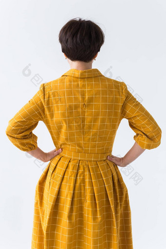 <strong>服装设计</strong>师人概念回来视图有吸引力的女人黄色的衣服摆姿势白色房间
