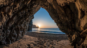 视图石头洞穴日落海海滩火山岩石洞穴基斯温暖的设置太阳火山玄武岩冰岛美世界自然在户外旅行概念