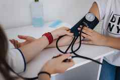 特写镜头医生血压计听诊器检查血压力女病人clicic