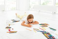 孩子女孩地板上画铅笔