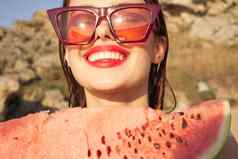 快乐的女人太阳镜西瓜自然岩石