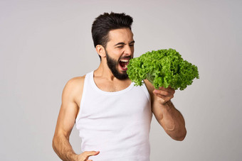 有胡子的男人。白色t恤生菜叶蔬菜健康的食物