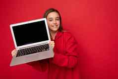 特写镜头肖像照片美丽的快乐微笑女孩长头发穿红色的连帽衫持有电脑移动PC相机孤立的红色的墙背景