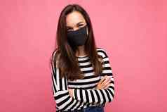 年轻的美丽的女人可重用的病毒保护面具脸冠状病毒孤立的粉红色的背景墙
