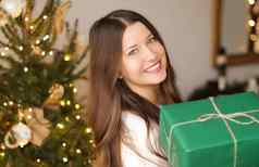 圣诞节假期可持续发展的礼物概念快乐微笑女人持有包装现在环保绿色包装纸