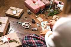 女人手包装圣诞节礼物盒子关闭裁剪女坐准备自然生态礼物地板上装饰元素项目快乐圣诞节一年Diy包装概念