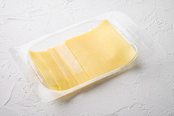 切片美味的伊丹奶酪塑料包白色石头背景