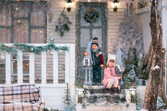 快乐孩子们坐着玄关圣诞节装饰房子户外