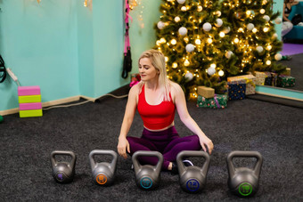 圣诞节健身女人微笑快乐的快乐美丽的快乐的高加索人女健身模型圣诞节树健身房