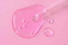 吸管流体透明质酸酸粉红色的背景化妆品医疗保健概念特写镜头