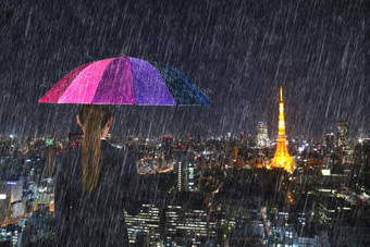 业务女人持有五彩缤纷的伞下降雨东京城市