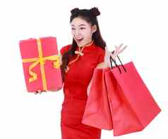 女人持有购物袋红色的礼物盒子概念中国人一年庆祝活动孤立的白色背景