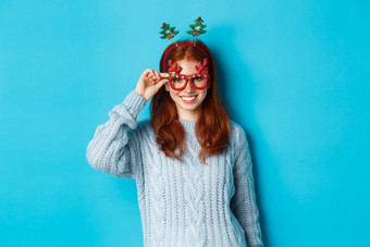 冬天假期圣诞节销售概念美丽的红色头发的人女模型庆祝一年穿有趣的聚会，<strong>派</strong>对头巾眼镜<strong>微</strong>笑相机