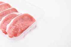 猪肉肉新鲜的猪肉牛排塑料包容器白色石头表格背景复制空间文本