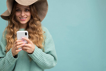 特写镜头肖像照片美丽的年轻的金发女郎女人穿蓝色的毛衣他站孤立的蓝色的背景冲浪互联网电话相机