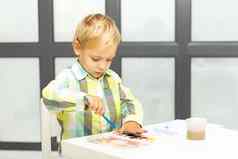 可爱的男孩油漆水彩画坐着选项卡
