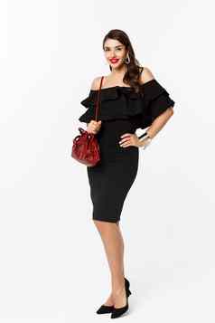 美时尚概念完整的长度优雅的年轻的女人购物黑色的衣服高跟鞋钱包自信站白色背景