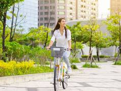 年轻的有吸引力的女人骑自行车城市公园