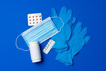 乳胶手套医疗面具药片蓝色的背景