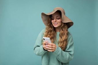 美丽的年轻的女人穿休闲衣服站孤立的背景冲浪互联网电话移动屏幕