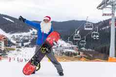 快乐男人。圣诞老人红色的圣诞节他滑雪板冬天山山