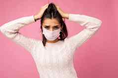 年轻的情感女人穿反病毒保护面具防止电晕科维德“非典”浸感染孤立的粉红色的背景