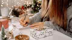 目标计划使列表一年圣诞节概念女孩写作笔记本女人手持有笔记事本首页冬天假期圣诞节圣诞节装饰礼物盒子