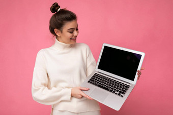 <strong>照片</strong>美丽的迷人的微笑女人聚集浅黑肤色的女人头发穿白色毛衣持有电脑移动PC上网本孤立的粉红色的<strong>墙背景</strong>