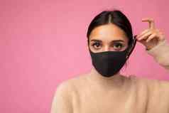 浅黑肤色的女人女人穿反病毒保护面具防止电晕科维德“非典”浸感染孤立的粉红色的背景