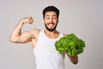 有胡子的男人。白色t恤生菜叶蔬菜健康的食物