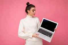 照片美丽的女人聚集浅黑肤色的女人头发穿白色毛衣持有电脑移动PC上网本孤立的粉红色的墙背景